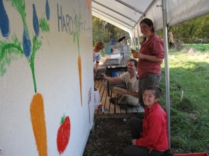 A perfect end-of-the season project:  Eli, Bill, Carolyn and Angelica painting the wall of our walk-in cooler with some giant carrots and tomatoes!